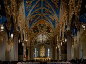 A view inside of the roman catholic basilica of the sacred heart where you can see the paintings of the ceiling, located in the University of Notre Dame